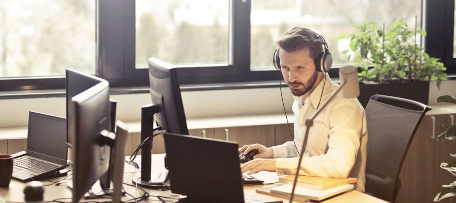 man-with-headphones-facing-computer-monitor-845451